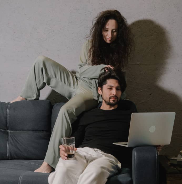 Kærestepar hygger på deres laptop med deres hurtige fibernet fra FiberTeamet